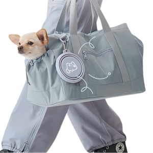 Gamelle Pliable pour Chien - Légère et Idéale pour les Aventures en Plein Air Petit chien dans sac de transport gris, gamelle silicone pliée accrochée sur le côté, avec médaille chien.